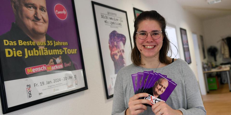 Bild von Jana Schäfer, wie sie Programmhefte in der Hand hält. 