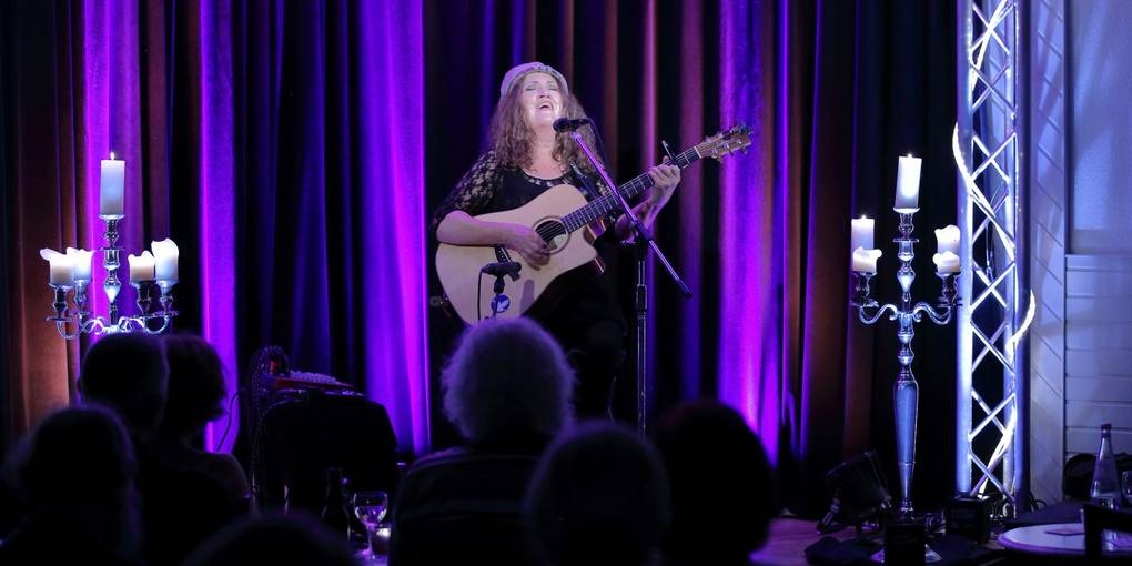 Haigis gibt ein Konzert im Café Extra, sie spielt Gitarre und singt.