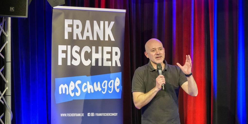 Ein Mann macht Stand-up auf der Bühne.